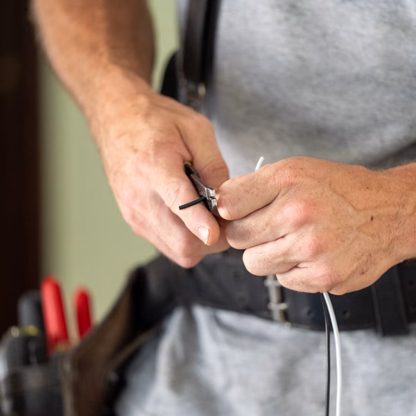 Evansville electrician's hands cutting an electrical wire.